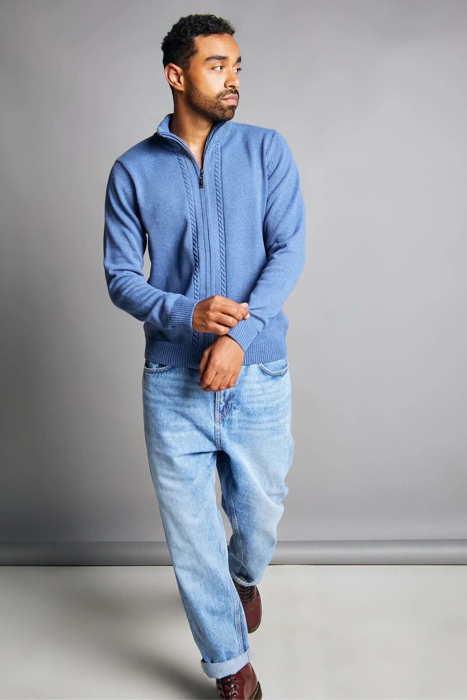 Hombre con suéter azul tejido de punto y jeans claros, moda casual para hombre