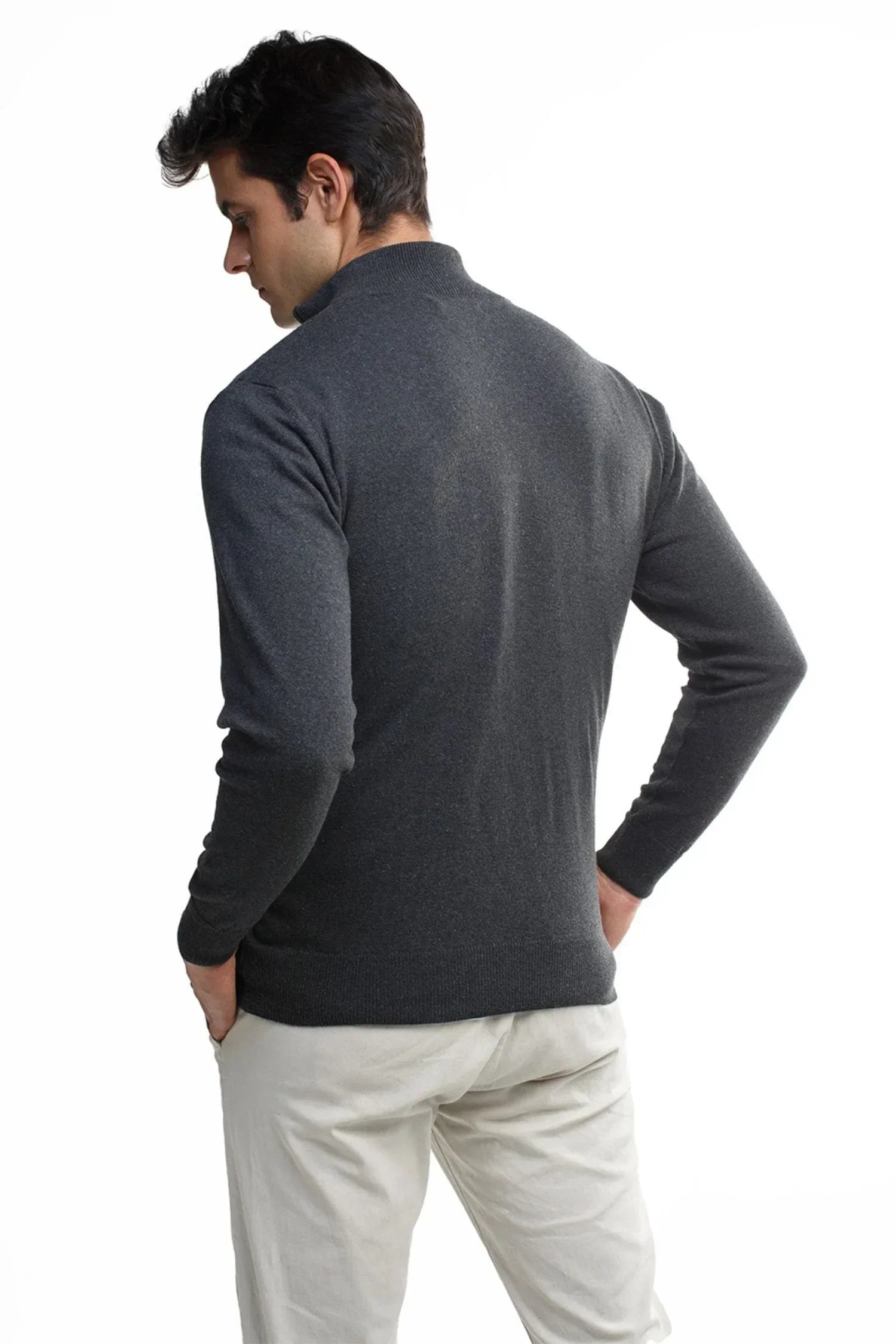 Hombre de espaldas con suéter gris de punto y pantalón claro, moda masculina elegante