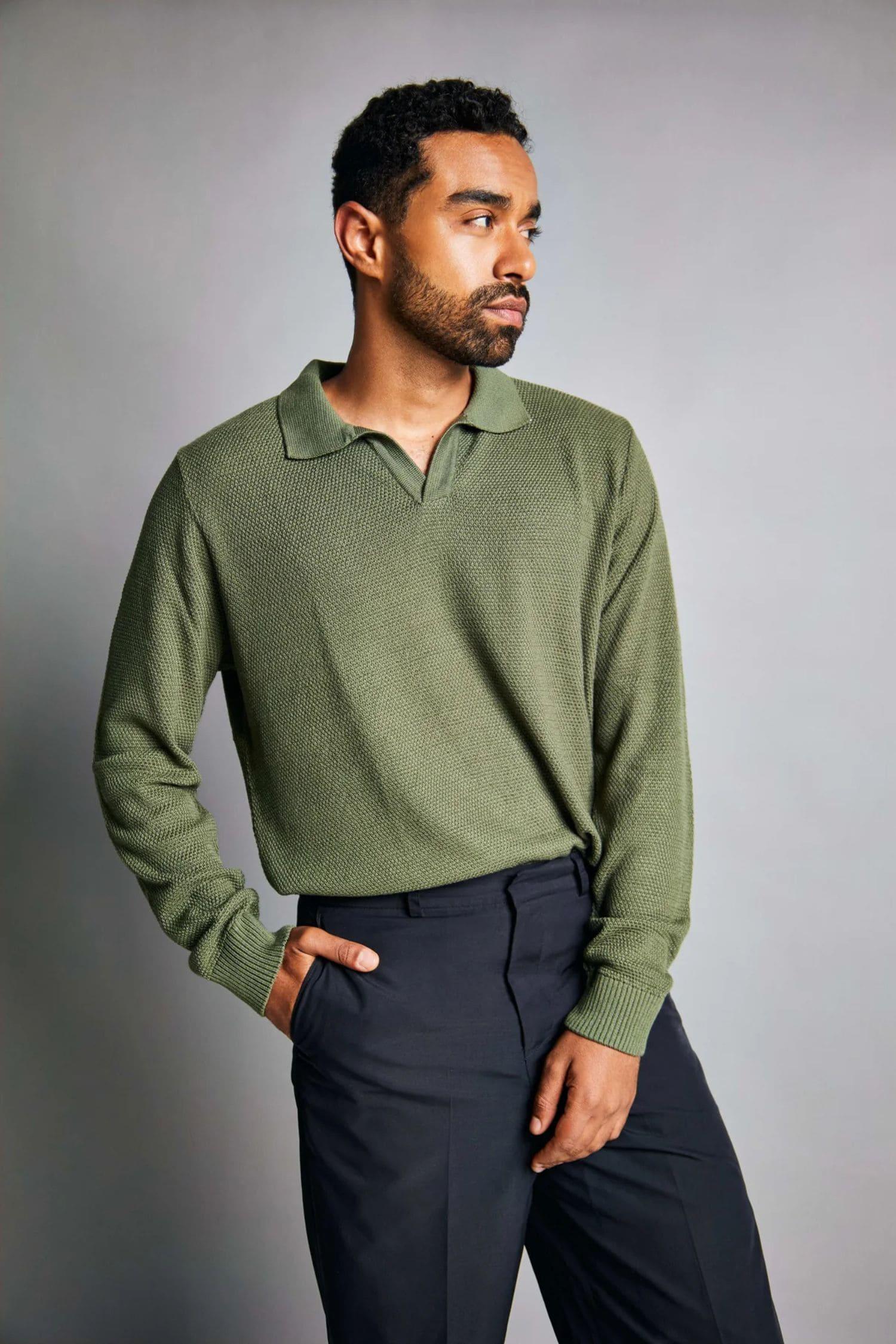 Hombre con suéter verde de punto y pantalón oscuro, ropa moderna para hombre.