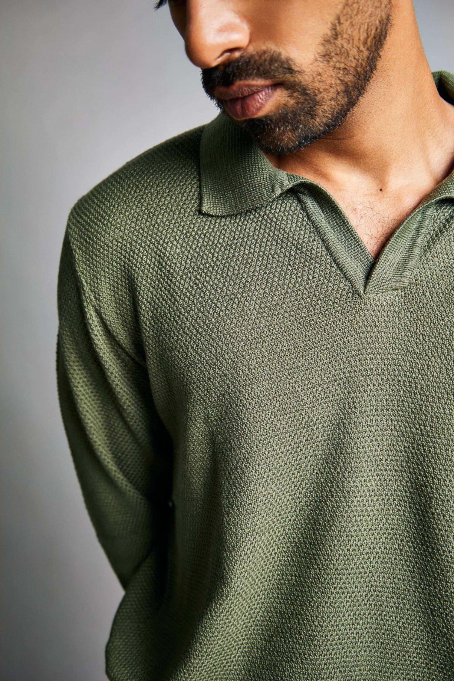 Primer plano de hombre con suéter verde de punto, textura gruesa y cuello tipo polo