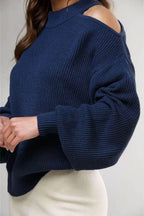 Suéter azul marino para mujer con hombros descubiertos y textura de punto grueso.