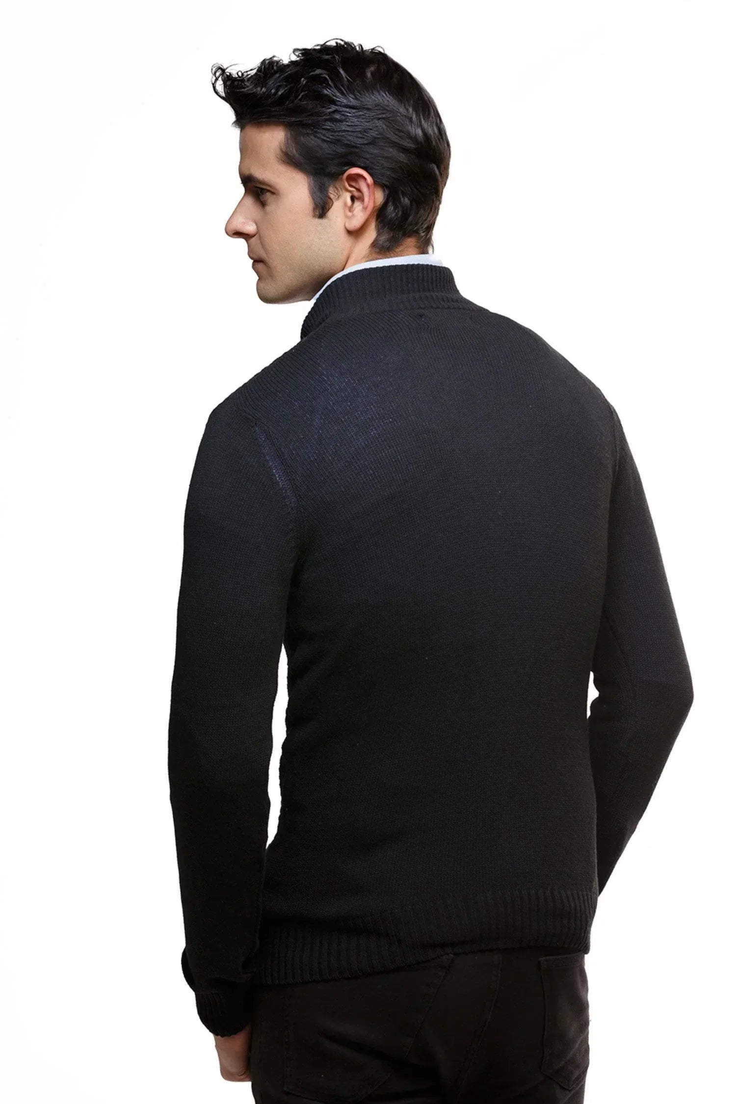 Hombre de espaldas vistiendo suéter tejido negro de punto, fondo blanco, moda masculina.