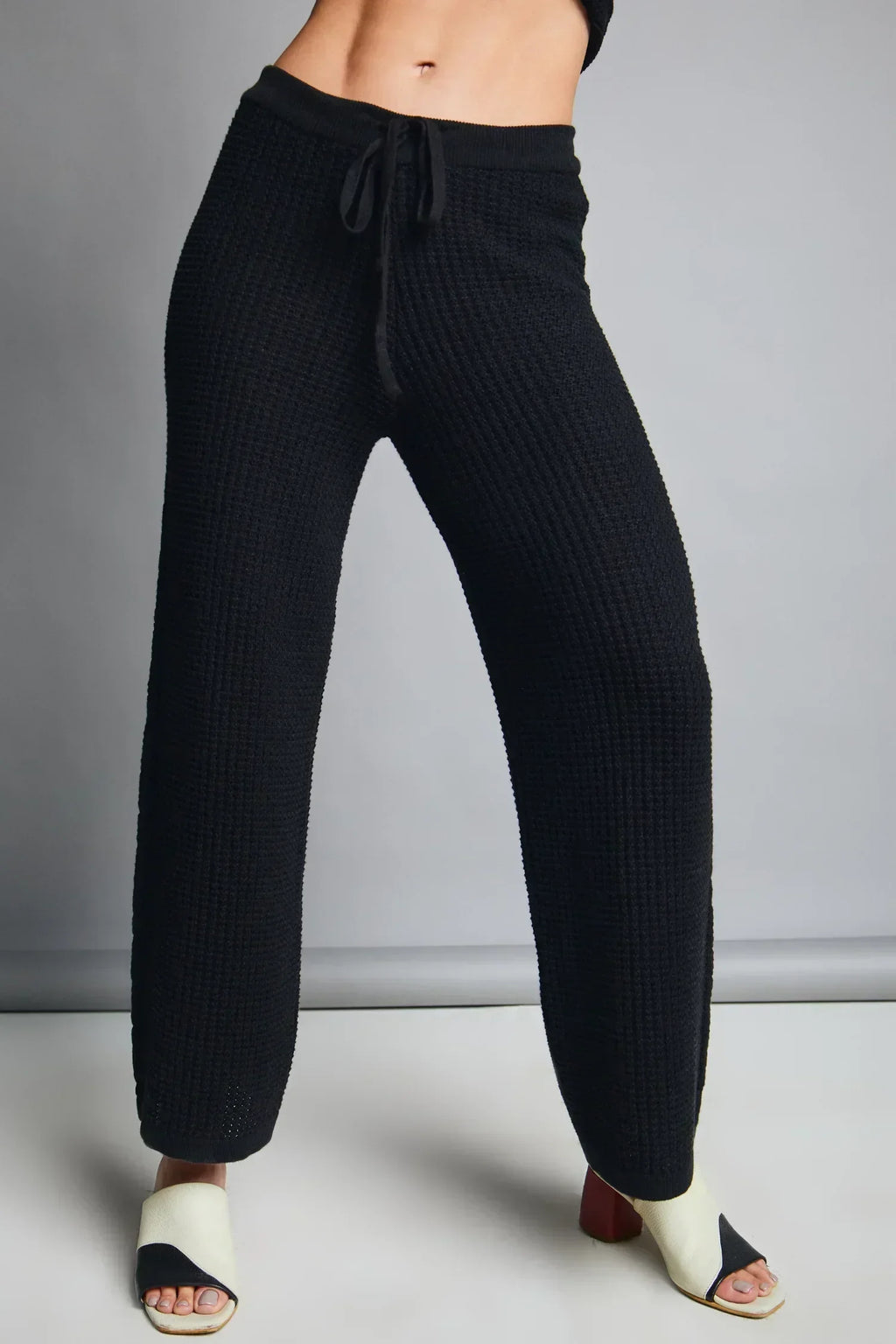 Pantalón tejido de mujer negro, corte recto y cintura ajustable, estilo casual y cómodo.