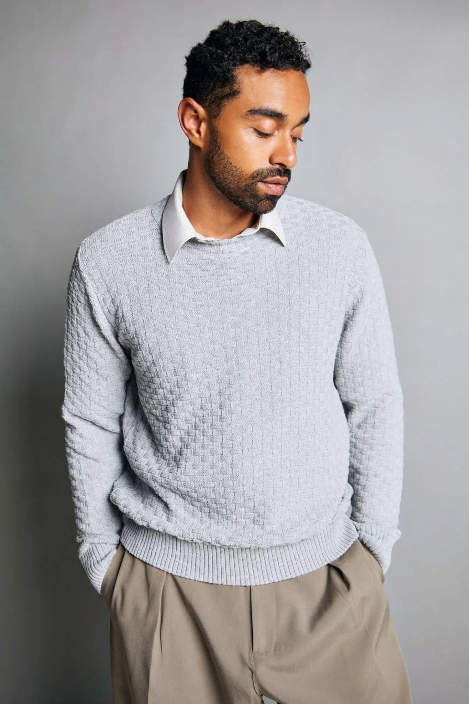 Hombre con suéter tejido gris claro y camisa blanca, moda masculina elegante
