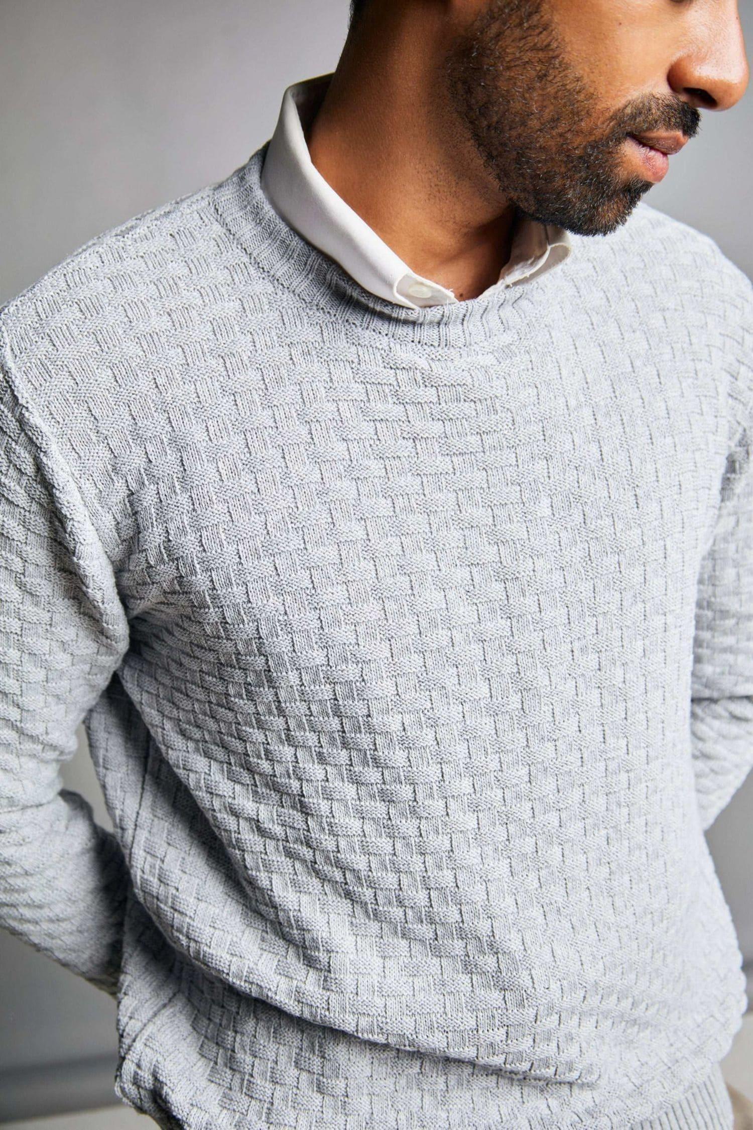 Suéter gris de tejido de punto para hombre con textura, sobre camisa blanca
