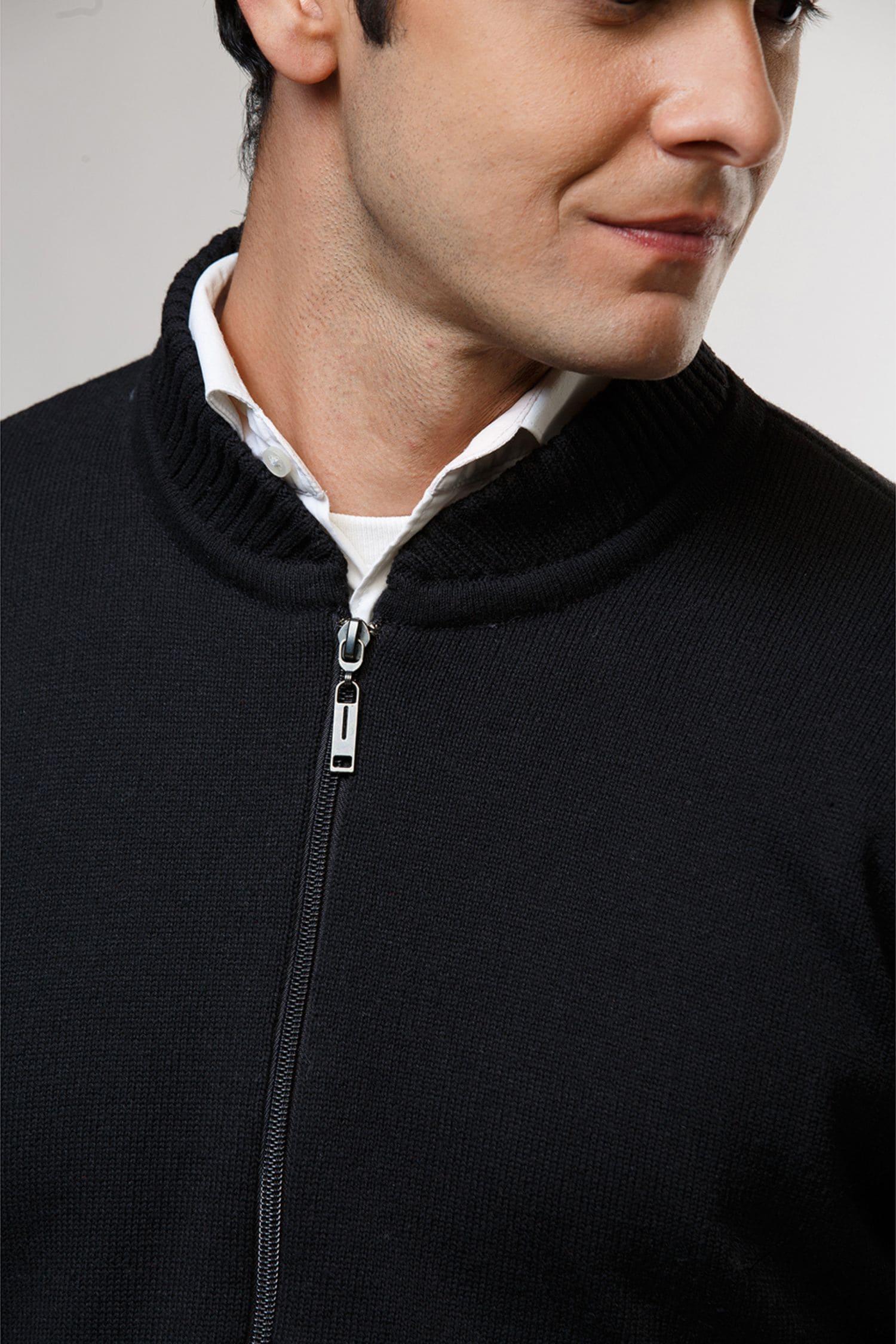 Chompa para hombre en tejido de punto negro con cierre, sobre camisa blanca