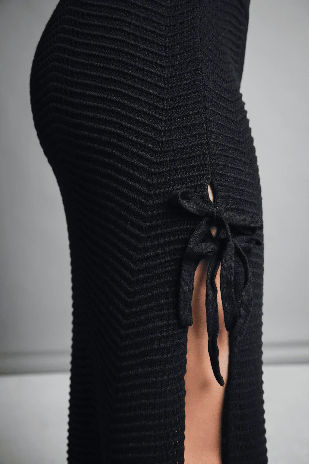 falda tejida negra con aberturas laterales y lazo decorativo, diseño moderno