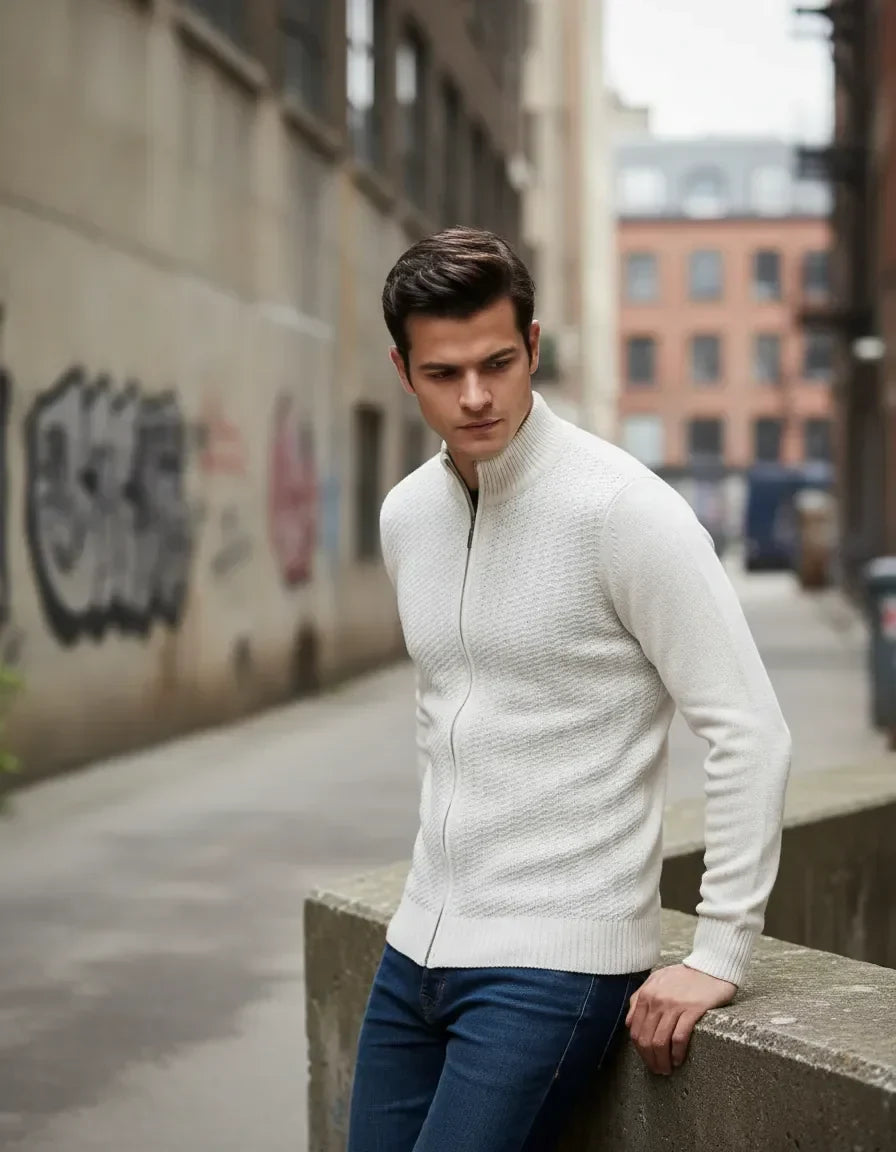 Hombre con suéter blanco de punto y cremallera, en calle urbana, estilo casual moderno
